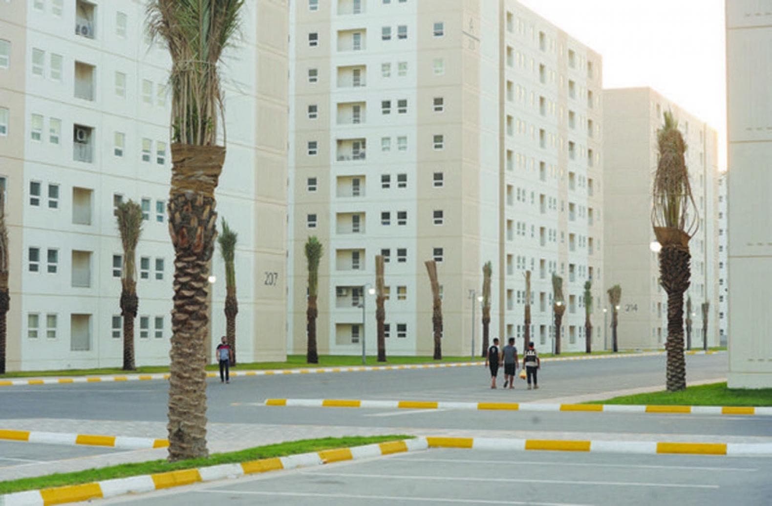 Palm-lined street between new apartment blocks of a modern housing complex in Iraq