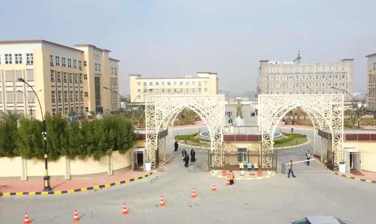 Ornamental white arches at a modern campus entrance in Najaf