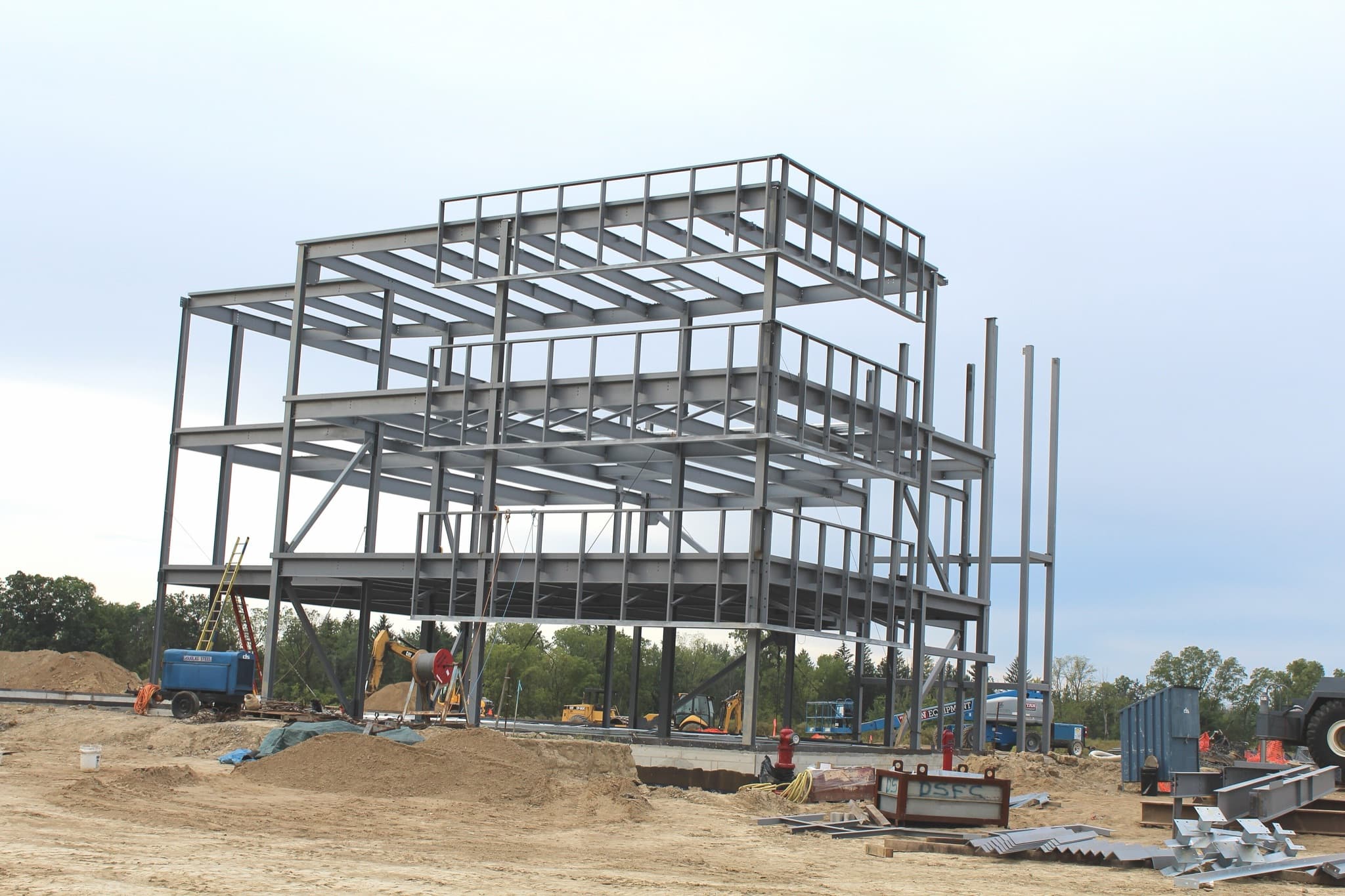 Structural steel frame of a commercial building rising on a Michigan construction site